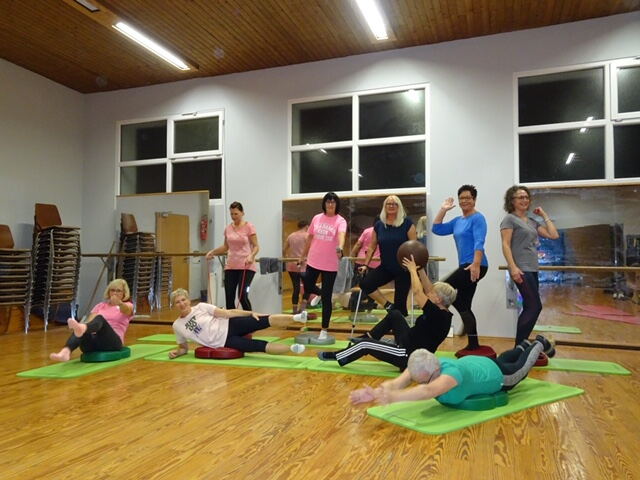 Gymnastikgruppe auf Matten in der Halle