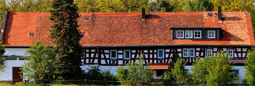 Fachwerkhaus des Landgasthofs Langfeldsmühle im Sonnenschein