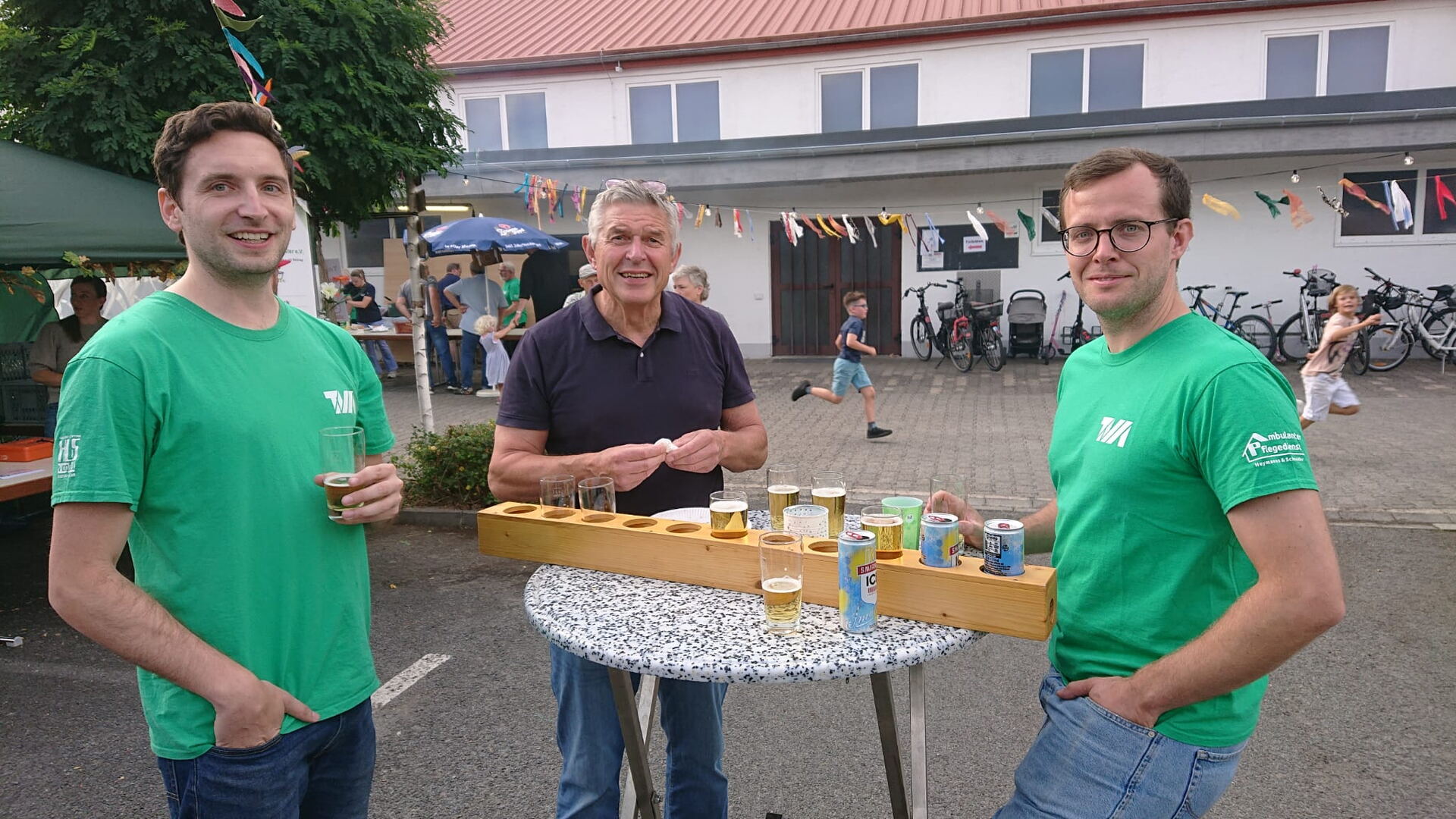 Helfer in grünen TVM-Shirts beim Sommerfest